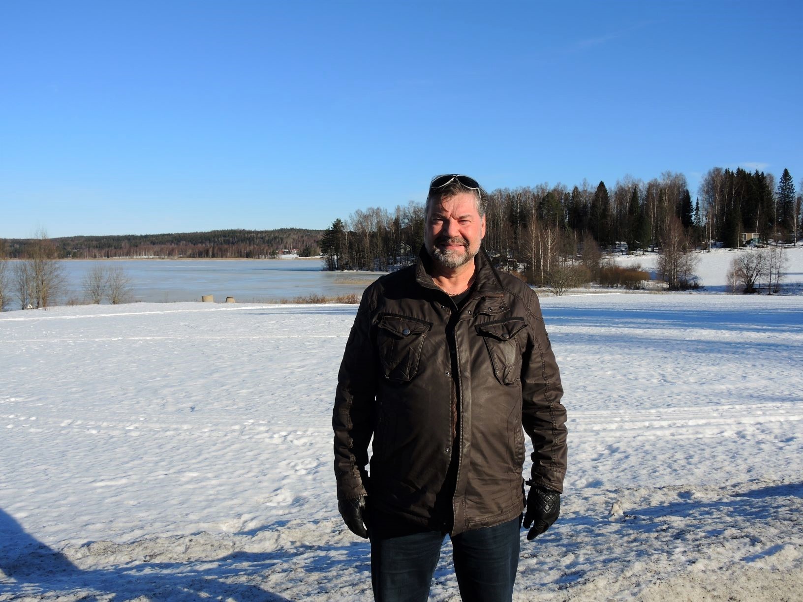 Mies seisoo pellolla keväthangessa